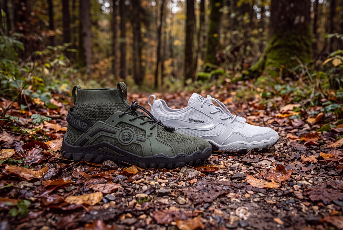 Barfußschuhe Tarka und Karoo nebeneinander auf nassem Herbstlaub und Schotter im Wald